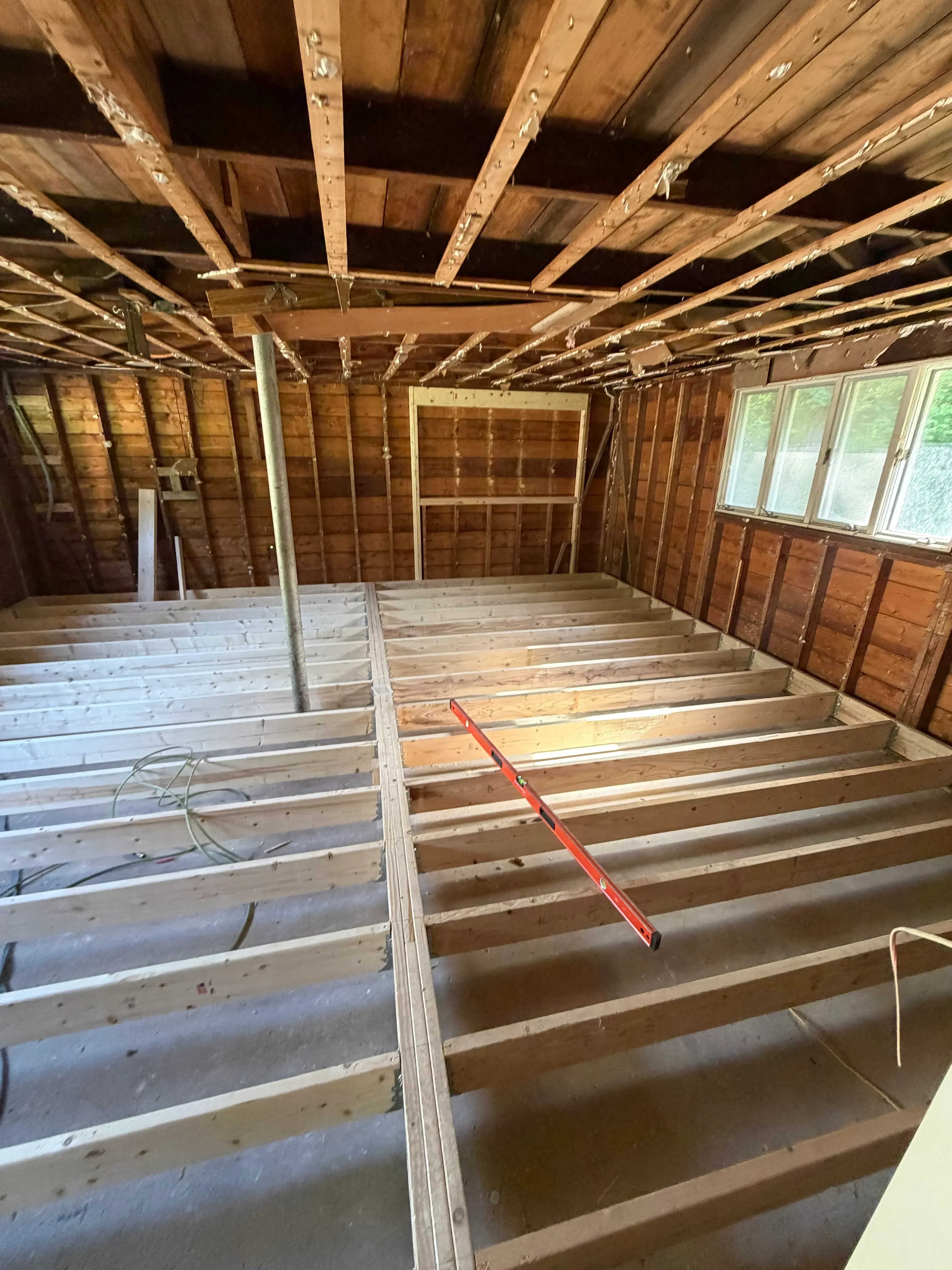 Roof framing with wooden trusses, metal bracing, and skylight openings during construction